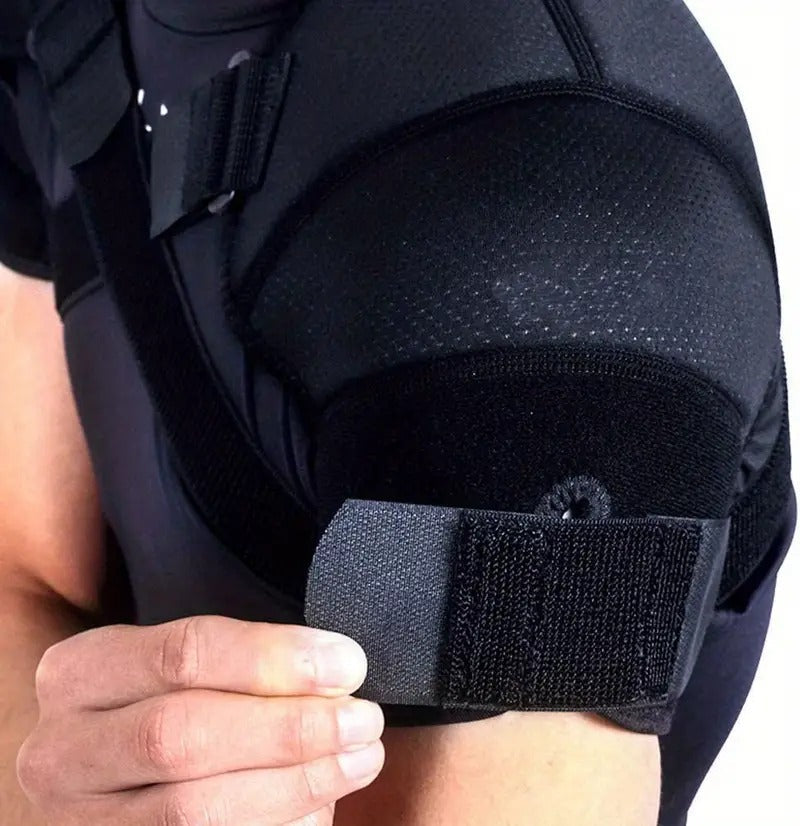 Black knee pad with a strap being worn on a person's knee.
