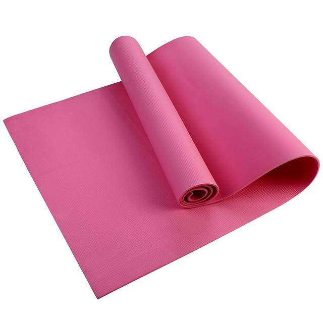 Pink yoga mat rolled up on a white background