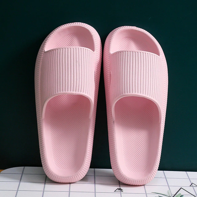 Pair of pink slippers on a dark green background