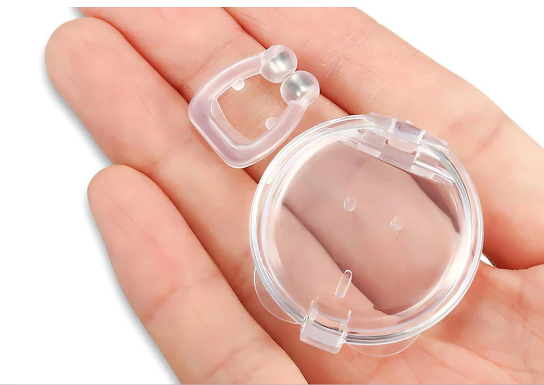 Transparent magnetic silicone nose clip in hero view showing conical comfort tips and bridge magnet designed to help support nasal airflow during sleep.