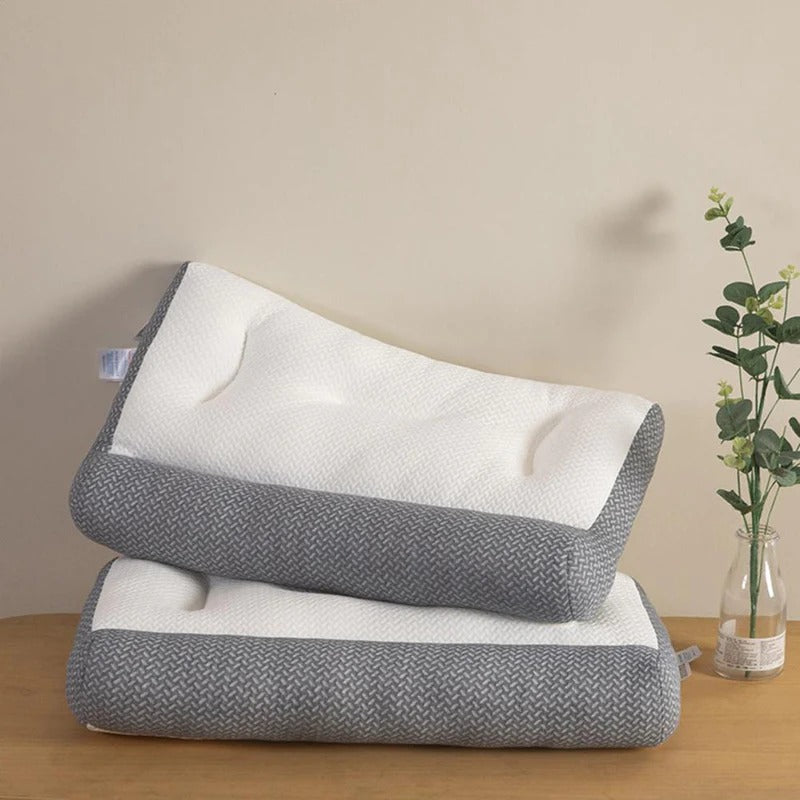 Two gray and white pillows stacked on a wooden surface with a beige wall in the background.
