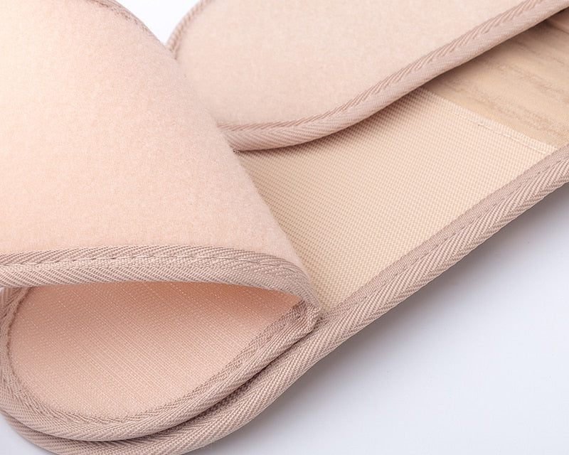 Close-up of a beige slipper with a textured sole on a white background