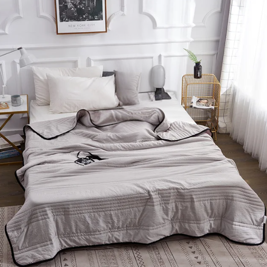 Lightweight premium cooling blanket in a hero view with thin-stripe pattern, showing breathable weave that helps disperse warmth on hot nights. 