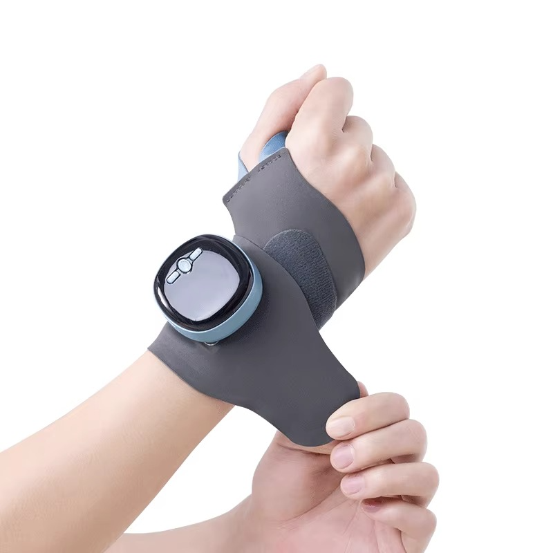 EMS heating wrist brace in a front hero view showing adjustable strap, soft fabric, and control panel for heat and vibration settings.